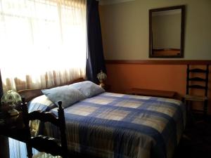 瓦拉斯科隆巴酒店的一间卧室设有一张床、一个窗口和一面镜子