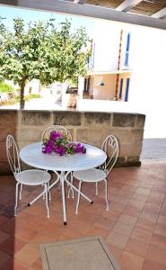 法维尼亚纳Favignana Casa Vacanza Orsola的庭院里配有白色的桌椅和鲜花