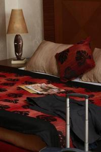 比绍Hala Hotel & Aqua Park的一间卧室配有一张床和一张带台灯的桌子