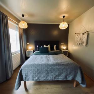 帕特雷克斯菲厄泽斯特卡波宾馆的一间卧室配有一张带蓝色被子的床和两盏灯。