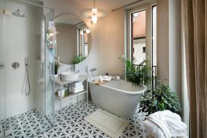 里加Redstone Apartments的带浴缸、两个盥洗盆和镜子的浴室