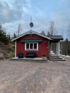 萨伦Lillhuset Norr Sälens By的前面有一张沙发的红色房子