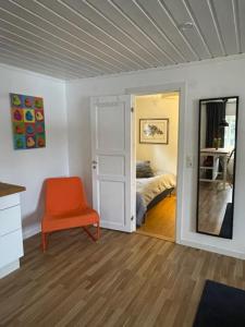 萨伦Lillhuset Norr Sälens By的一间带橙色椅子的客厅和一间卧室