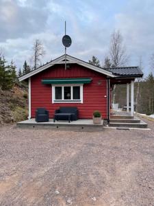 萨伦Lillhuset Norr Sälens By的前面有两把蓝色椅子的红色房子