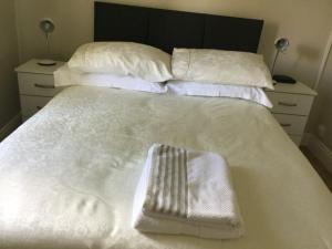 利默里克Adare Luxury Riverside Apartment的白色的床、白色毛巾和枕头
