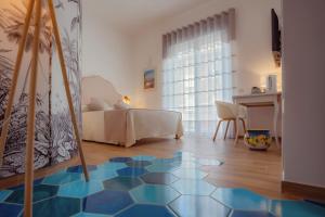 马奥莱La Serenata Luxury的卧室配有床,铺有蓝色和白色的地板