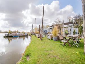 诺德克豪特Lovely Bungalow in Noordwijkerhout with Garden的河边野餐桌,有船