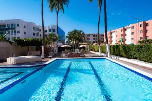 曼萨尼约Suites Santa Barbara的一座棕榈树和建筑游泳池