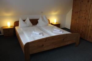约克Hotel Alte Schmiede Jork的一间卧室配有一张带两盏灯的大木床。