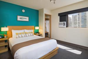 檀香山威基基VIVE酒店的一间卧室设有一张大床和蓝色的墙壁