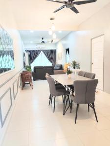 Rantau PanjangPrivate pool Cassa Dinies, Wifi , Bbq,10 pax的用餐室以及带桌椅的起居室。