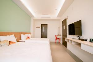 马公向日葵精致旅店民宿的一间酒店客房,设有两张床和电视