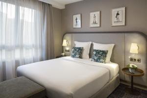 里昂里昂华威雷奥斯特公寓式酒店的卧室设有一张白色大床和一扇窗户。