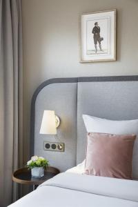 里昂里昂华威雷奥斯特公寓式酒店的一间卧室配有一张床和一张带台灯的桌子