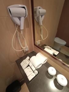 雅加达卡里巴塔瑞士贝尔住宅酒店的一间带电话、水槽和卫生间的浴室