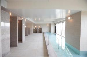 川崎川崎国王天际东急REI酒店的大楼内带游泳池的走廊