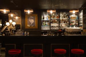 米兰Speronari Suites的吧台前有红色凳子的酒吧