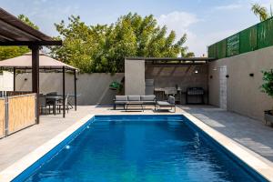 埃拉特YalaRent Caesar's Villa with Private Pool的游泳池,带桌椅的庭院