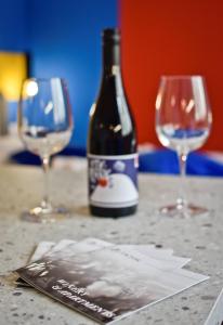 索普隆ZACHÁR APARTMAN的一张桌子上摆放着一瓶葡萄酒和两杯酒杯