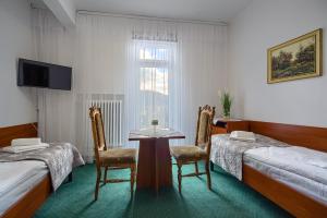 克雷尼察Dom Wczasowy Zdrowie的一间设有两张床和一张桌子及椅子的房间