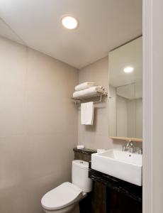 贝克西勿加泗萨提卡麦格酒店的一间带卫生间、水槽和镜子的浴室