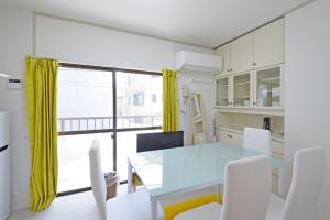 东京Oji Natural Cosy House的一间配备有蓝桌和白色椅子的用餐室