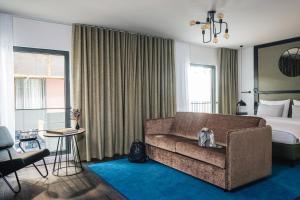 慕尼黑AMERON München Motorworld的酒店客房设有一张沙发和一张床