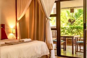 维多利亚瀑布Dzimbahwe Guest Lodge的一间卧室设有一张床和一个滑动玻璃门
