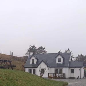 DervaigArd Na Mara Self Catering Isle of Mull的草山顶上的白色房子