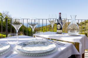 科斯特曼诺Deville & Spa的一张带玻璃杯和盘子的桌子和一瓶葡萄酒