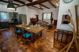 阿维尼翁La Maison du Moulin de Tartay的厨房以及带木桌和椅子的客厅。