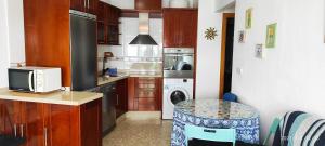 莫切Apartamento Luminoso el Morche的厨房配有微波炉、洗衣机和烘干机