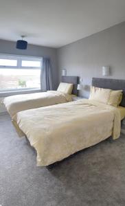 Boston SpaLarge 4 bedroom home in Boston Spa village In-between York, Harrogate and Leeds, Sleeps 9的卧室设有2张床和窗户。