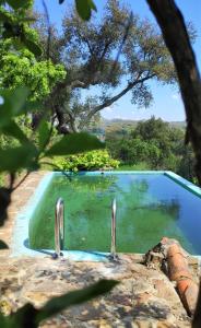 马尔旺Monte das Cascatas的一座游泳池,旁边是两根金属栏杆