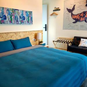 台东老余民宿的一间卧室配有蓝色的床和椅子