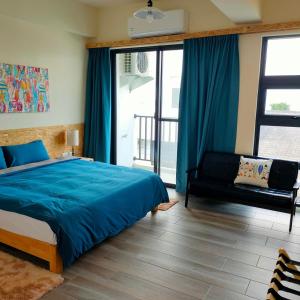台东老余民宿的一间卧室配有蓝色的床和沙发