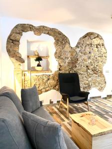 埃尔乔罗柯波尔佳甘塔酒店的客厅设有石墙、沙发和椅子