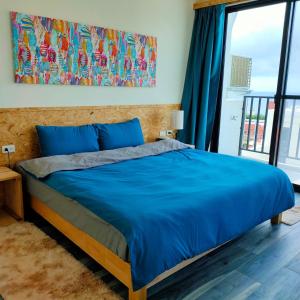 台东老余民宿的一间卧室设有蓝色的床和大窗户