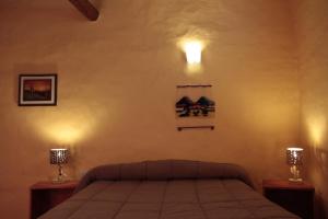 蒂尔卡拉Hosteria La Estacion的卧室配有一张带两盏灯的墙壁床。