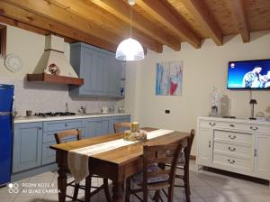 皮索涅CASA DELLE API的厨房配有木桌、椅子和电视