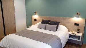CoveloHotel La Rectoral的卧室配有一张带两个枕头的大白色床
