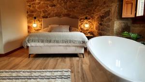 CoveloHotel La Rectoral的一间卧室配有一张床和浴缸