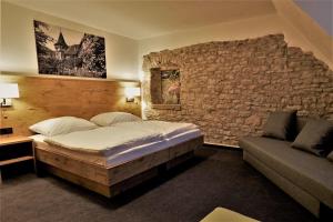 ForchtenbergKelterhotel Fröscher的一间卧室设有一张床和石墙