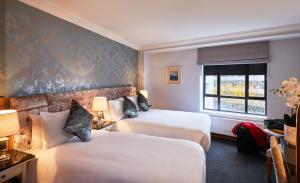 都柏林Handel's Hotel的酒店客房设有两张床和窗户。