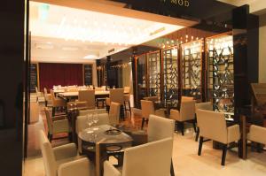 门多萨门多萨莫德酒店的一间带桌椅和葡萄酒架的用餐室