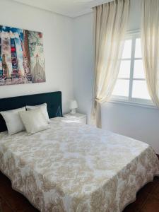 阿德耶Duplex Penthouse Panoramic Del Atlantico的一间卧室设有一张大床和一个窗户。