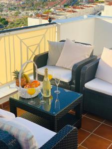 阿德耶Duplex Penthouse Panoramic Del Atlantico的庭院配有带饮品和水果篮的桌子