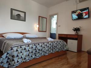 LukaPansion Alen - Dugi otok的一间卧室配有一张床,上面有两条毛巾