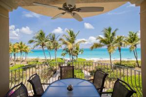 格雷斯湾Villa Renaissance Unit 205 Grace Bay Beach的一间享有海滩和棕榈树美景的用餐室
