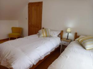 DervaigArd Na Mara Self Catering Isle of Mull的一间卧室配有两张床和一张黄色椅子